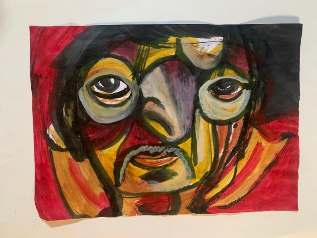 Rosto amarelo e vermelho de olhos grandes e bigode, sobre fundo preto e vermelho